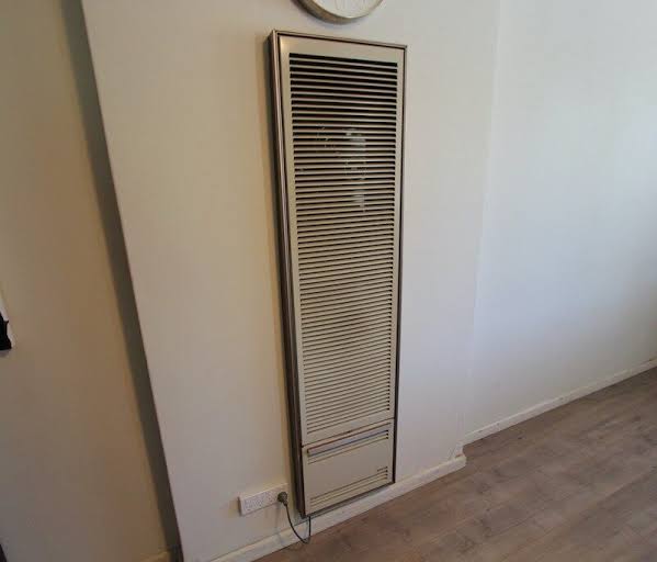 Wall furnace grille set into a hallway wall